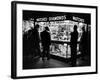 Customers Peering at the Wares Inside a Small, Brightly Lit Times Square Jewelry and Watch Shop-Peter Stackpole-Framed Photographic Print