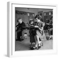 Cute Little Girl Busily at Work, Sitting in a Desk Chair in a Schoolroom, Other Pupils at Work Too-Gordon Parks-Framed Photographic Print