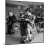 Cute Little Girl Busily at Work, Sitting in a Desk Chair in a Schoolroom, Other Pupils at Work Too-Gordon Parks-Mounted Photographic Print