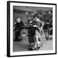 Cute Little Girl Busily at Work, Sitting in a Desk Chair in a Schoolroom, Other Pupils at Work Too-Gordon Parks-Framed Photographic Print