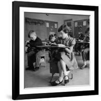 Cute Little Girl Busily at Work, Sitting in a Desk Chair in a Schoolroom, Other Pupils at Work Too-Gordon Parks-Framed Photographic Print