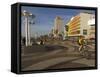 Cyclist on Jerusalem Beach Promenade with Dan Hotel Facade Decorated by Yaaqov Agam in Background-Eitan Simanor-Framed Stretched Canvas