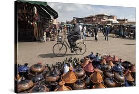 Cyclist Passing a Stall Selling Traditional Clay Tajine Cooking Pots in Place Jemaa El-Fna-Martin Child-Stretched Canvas