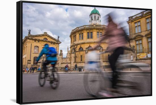 Cyclists Passing the Sheldonian Theatre, Oxford, Oxfordshire, England, United Kingdom, Europe-John Alexander-Framed Stretched Canvas
