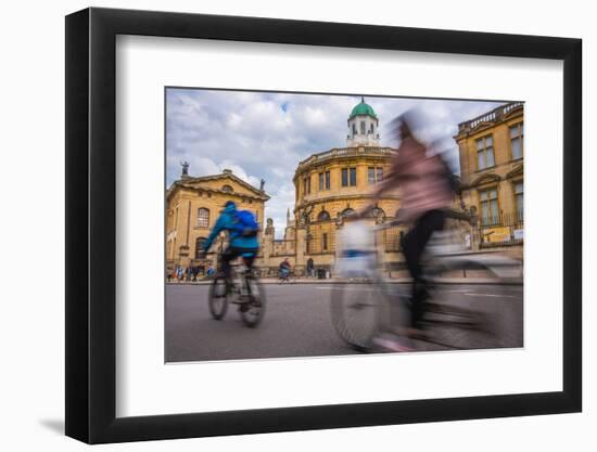 Cyclists Passing the Sheldonian Theatre, Oxford, Oxfordshire, England, United Kingdom, Europe-John Alexander-Framed Photographic Print