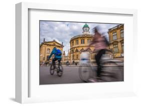 Cyclists Passing the Sheldonian Theatre, Oxford, Oxfordshire, England, United Kingdom, Europe-John Alexander-Framed Photographic Print