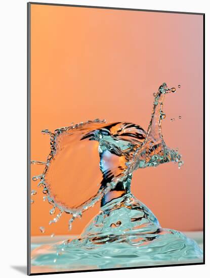Dancing Water Droplet High Speed Photography on an Orange Background-Circumnavigation-Mounted Photographic Print