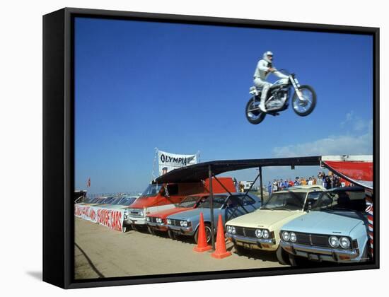 Daredevil Motorcyclist Evil Knievel in Mid Jump over a Row of Cars-Ralph Crane-Framed Stretched Canvas