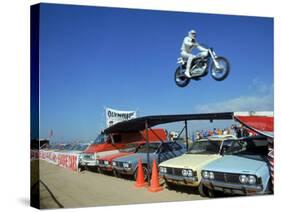 Daredevil Motorcyclist Evil Knievel in Mid Jump over a Row of Cars-Ralph Crane-Stretched Canvas