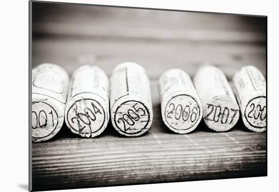 Dated Wine Bottle Corks On The Wooden Background-null-Mounted Poster