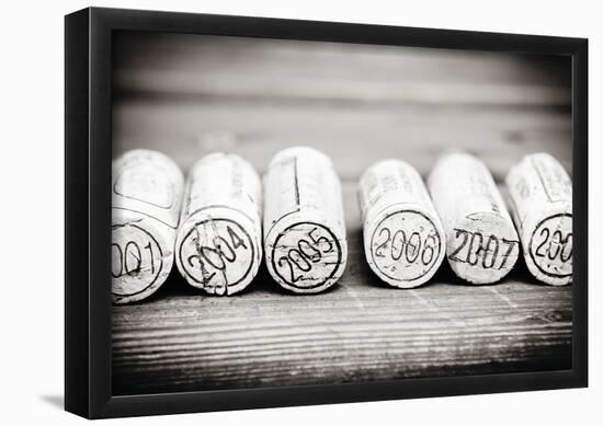 Dated Wine Bottle Corks On The Wooden Background-null-Framed Poster