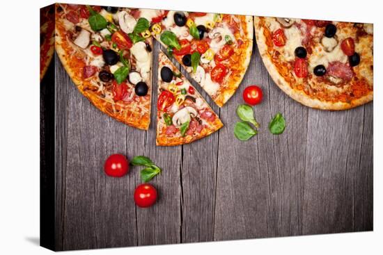 Delicious Italian Pizzas Served on Wooden Table-Jag_cz-Stretched Canvas