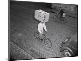 Delivery Boy Riding Bicycle with Box on Head-null-Mounted Photographic Print