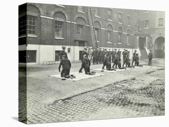 Demonstrating How to Pick Up an Unconscious Person, London Fire Brigade Headquarters, London, 1910-null-Stretched Canvas