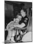 Den Mother Still in Uniform, Sleeping While Holding Her Daughter-null-Mounted Photographic Print