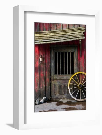 Detail of Old Wagon Wheel next to a Wooden Wild West Typical House-ccaetano-Framed Photographic Print