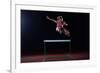 Determined Young Woman Athlete Jumping over a Hurdles-dotshock-Framed Photographic Print