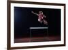 Determined Young Woman Athlete Jumping over a Hurdles-dotshock-Framed Photographic Print