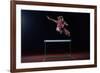 Determined Young Woman Athlete Jumping over a Hurdles-dotshock-Framed Photographic Print