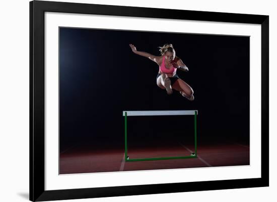 Determined Young Woman Athlete Jumping over a Hurdles-dotshock-Framed Photographic Print