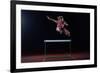 Determined Young Woman Athlete Jumping over a Hurdles-dotshock-Framed Photographic Print
