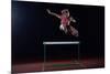 Determined Young Woman Athlete Jumping over a Hurdles-dotshock-Mounted Photographic Print