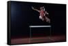 Determined Young Woman Athlete Jumping over a Hurdles-dotshock-Framed Stretched Canvas