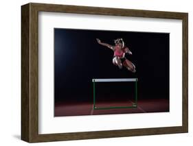 Determined Young Woman Athlete Jumping over a Hurdles-dotshock-Framed Photographic Print