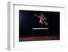 Determined Young Woman Athlete Jumping over a Hurdles-dotshock-Framed Photographic Print