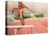 Digital Composite Image of Female Athlete Jumping above the Hurdle against Cityscape Background-vectorfusionart-Stretched Canvas