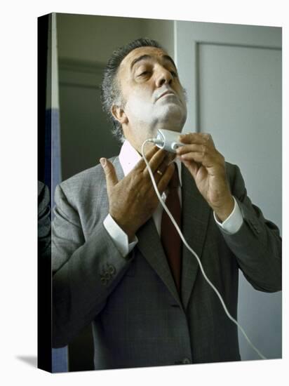 Director Federico Fellini with Powder on His Face as He Shaves with an Electric Shaver-Carlo Bavagnoli-Stretched Canvas