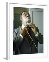 Director Federico Fellini with Powder on His Face as He Shaves with an Electric Shaver-Carlo Bavagnoli-Framed Photographic Print