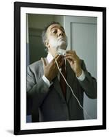 Director Federico Fellini with Powder on His Face as He Shaves with an Electric Shaver-Carlo Bavagnoli-Framed Photographic Print