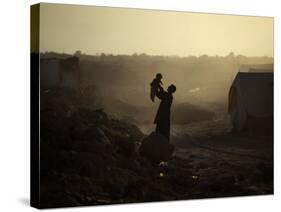 Displaced Man Holds His Baby Next to His Tent in Jalozai Refugee Camp Near Peshawar, Pakistan-null-Stretched Canvas