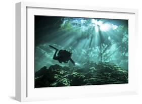 Diver Passes Through Light Beams in Chac Mool Cenote in Mexico-null-Framed Photographic Print