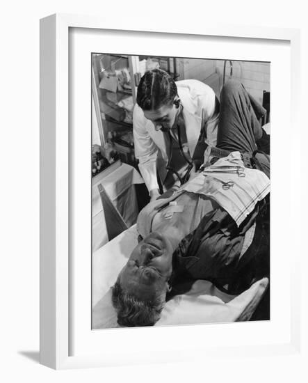 Doctor Attends to Injured Man-null-Framed Photographic Print