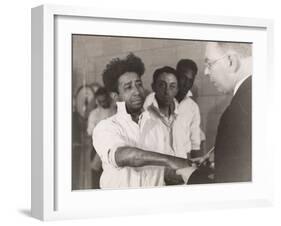 Doctor examining inmate's hand-Lucien Aigner-Framed Photographic Print