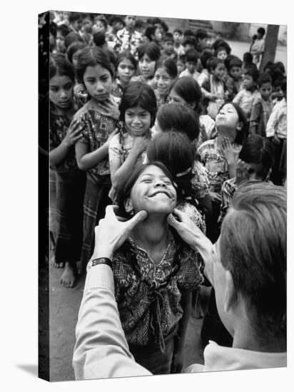 Dr. Nevin S. Scrimshaw of the Central American Institute of Nutrition Examining Children for Goiter-Cornell Capa-Stretched Canvas