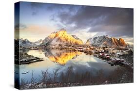 Dramatic sky at dawn over Mount Olstind covered with snow, Reine Bay, Nordland, Lofoten Islands-Roberto Moiola-Stretched Canvas