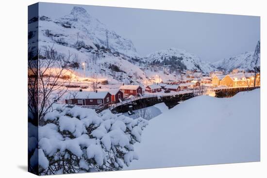 Dusk lights on the fishing village surrounded by snowy peaks, Nusfjord, Northern Norway-Roberto Moiola-Stretched Canvas