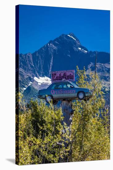 Eads Auto, Seward Alaska - a car in the trees under a large mountain-null-Stretched Canvas