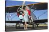 Elegant 1940's Style Pin-Up Girl Standing in Front of an F3F Biplane-null-Stretched Canvas