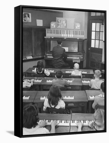 Elementary School Music Teacher Playing F-Major Chord on Piano, Keys Light up on Plastic Keyboard-Yale Joel-Framed Stretched Canvas