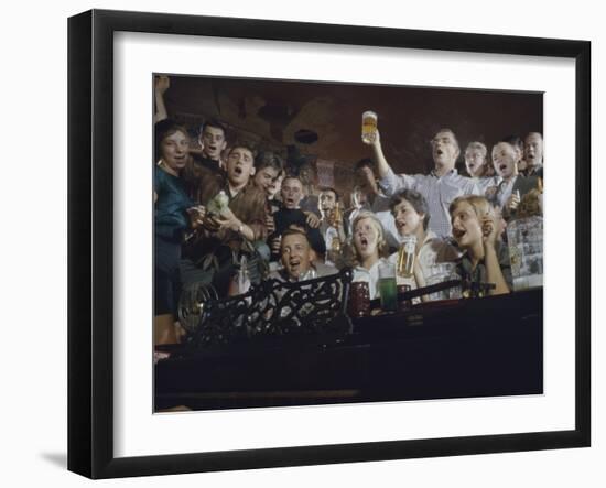 Elevated View of a Group of People as They Sing Along with a Pianist in a Unidentified Bar, 1959-Yale Joel-Framed Photographic Print