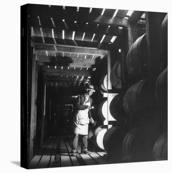 Employee in Warehouse of Jack Daniels Distillery Checking For Leaks in the Barrels-Ed Clark-Stretched Canvas