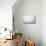 Empty Room with White Brick Wall and Wooden Floor-auris-Mounted Art Print displayed on a wall