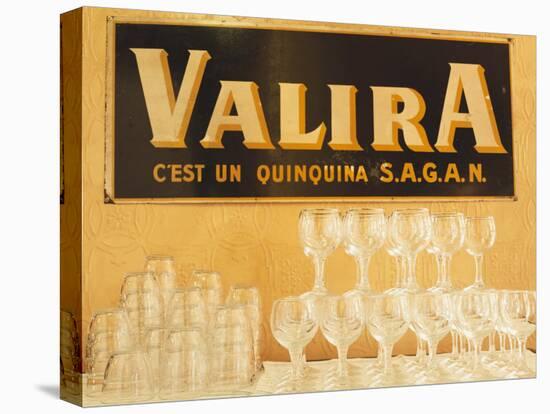 Empty Wine & Water Glasses in Front of Valira Publicity Sign-Peter Medilek-Stretched Canvas