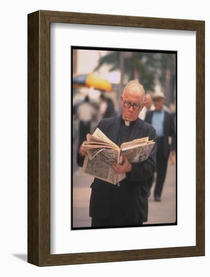 Episcopalian Priest Reading a Newspaper While Walking in Street, New York City-Vernon Merritt III-Framed Photographic Print