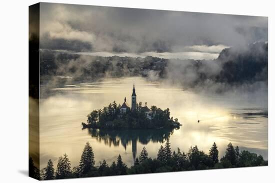 Europe, Slovenia, Bled - A Pletna Boat Arriving At The Island Of Lake Bled During A Foggy Sunrise-Aliaume Chapelle-Stretched Canvas