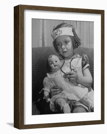 Evelyn Mott playing Nurse with doll as parents adjust children to abnormal conditions in wartime-Alfred Eisenstaedt-Framed Photographic Print